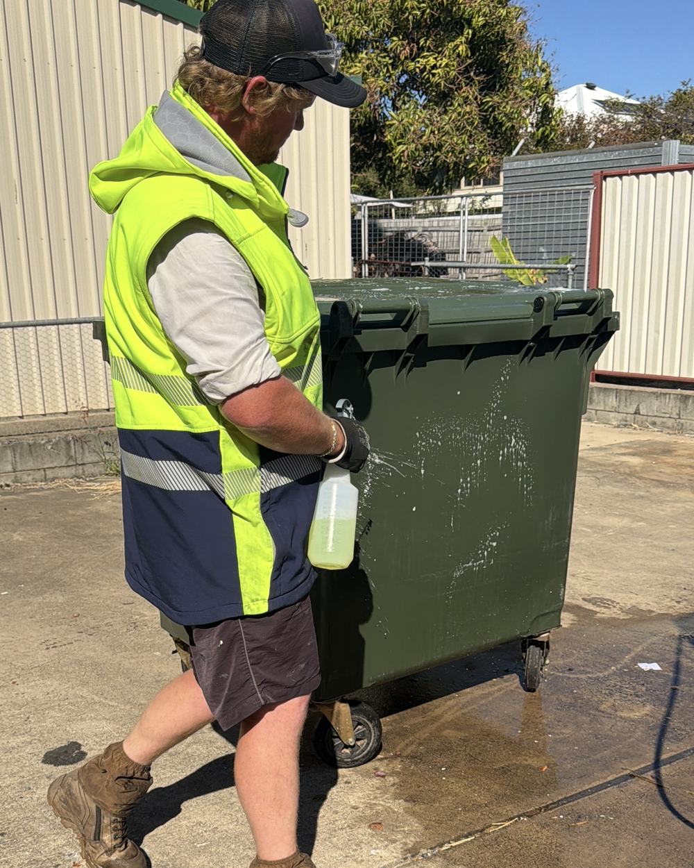 Cleaning a commercial bin in a business service yard